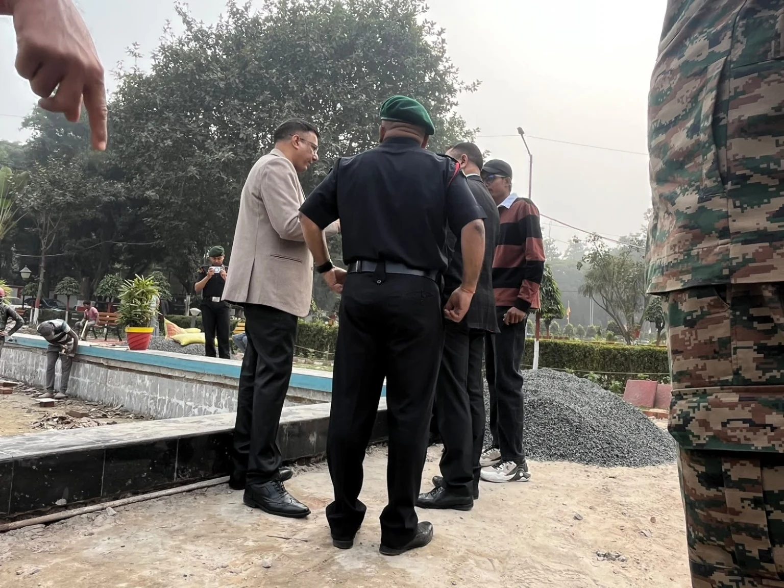 A group looking at a stone-edged landscape feature during a site visit